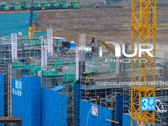 Workers brave the rain as they work at the construction site of the Erhe Junction project of the second phase of the Huaihe River Waterway i...