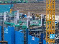 Workers brave the rain as they work at the construction site of the Erhe Junction project of the second phase of the Huaihe River Waterway i...