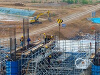 Workers brave the rain as they work at the construction site of the Erhe Junction project of the second phase of the Huaihe River Waterway i...