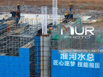 Workers brave the rain as they work at the construction site of the Erhe Junction project of the second phase of the Huaihe River Waterway i...