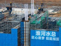 Workers brave the rain as they work at the construction site of the Erhe Junction project of the second phase of the Huaihe River Waterway i...