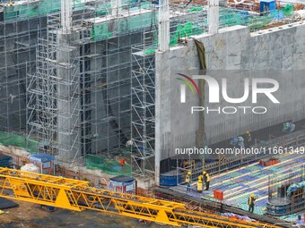 Workers brave the rain as they work at the construction site of the Erhe Junction project of the second phase of the Huaihe River Waterway i...