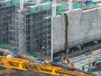 Workers brave the rain as they work at the construction site of the Erhe Junction project of the second phase of the Huaihe River Waterway i...