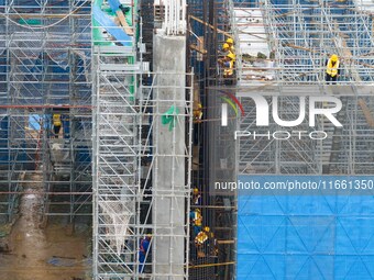 Workers brave the rain as they work at the construction site of the Erhe Junction project of the second phase of the Huaihe River Waterway i...