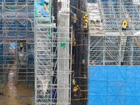 Workers brave the rain as they work at the construction site of the Erhe Junction project of the second phase of the Huaihe River Waterway i...