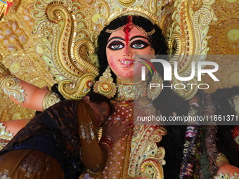 A Hindu woman performs worship of the idol of the Hindu goddess Durga before it is immersed in the Hooghly River during the Durga Puja festi...