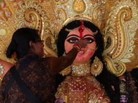 A Hindu woman performs worship of the idol of the Hindu goddess Durga before it is immersed in the Hooghly River during the Durga Puja festi...