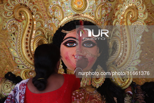 A Hindu woman performs worship of the idol of the Hindu goddess Durga before it is immersed in the Hooghly River during the Durga Puja festi...