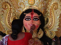 A Hindu woman performs worship of the idol of the Hindu goddess Durga before it is immersed in the Hooghly River during the Durga Puja festi...