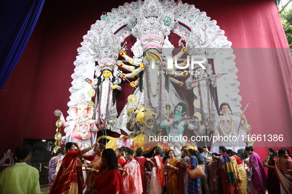 Hindu women perform worship of the idol of the Hindu goddess Durga before it is immersed in the Hooghly River during the Durga Puja festival...