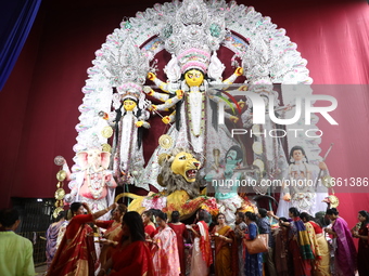 Hindu women perform worship of the idol of the Hindu goddess Durga before it is immersed in the Hooghly River during the Durga Puja festival...