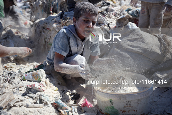 A photo shows Palestinian youths collecting remains of spoiled flour discarded in a makeshift landfill near the tents of displaced people in...