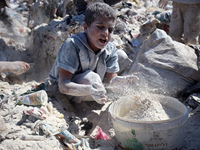 A photo shows Palestinian youths collecting remains of spoiled flour discarded in a makeshift landfill near the tents of displaced people in...