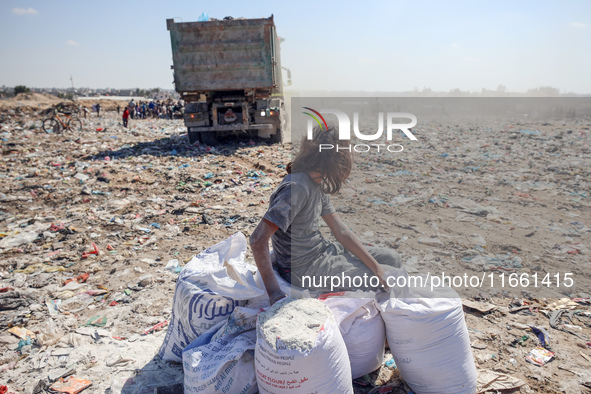 A photo shows Palestinian youths collecting remains of spoiled flour discarded in a makeshift landfill near the tents of displaced people in...