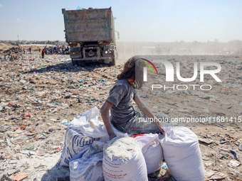 A photo shows Palestinian youths collecting remains of spoiled flour discarded in a makeshift landfill near the tents of displaced people in...