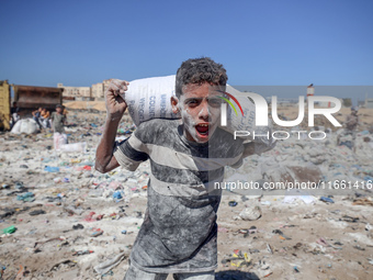 A photo shows Palestinian youths collecting remains of spoiled flour discarded in a makeshift landfill near the tents of displaced people in...