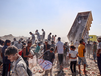 A photo shows Palestinian youths collecting remains of spoiled flour discarded in a makeshift landfill near the tents of displaced people in...