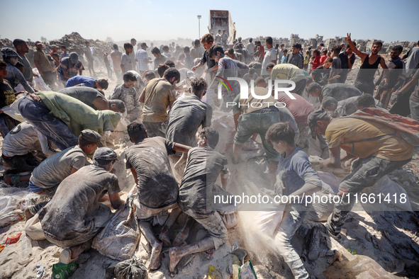 A photo shows Palestinian youths collecting remains of spoiled flour discarded in a makeshift landfill near the tents of displaced people in...