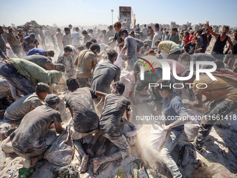 A photo shows Palestinian youths collecting remains of spoiled flour discarded in a makeshift landfill near the tents of displaced people in...