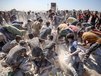 A photo shows Palestinian youths collecting remains of spoiled flour discarded in a makeshift landfill near the tents of displaced people in...