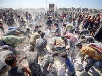 A photo shows Palestinian youths collecting remains of spoiled flour discarded in a makeshift landfill near the tents of displaced people in...