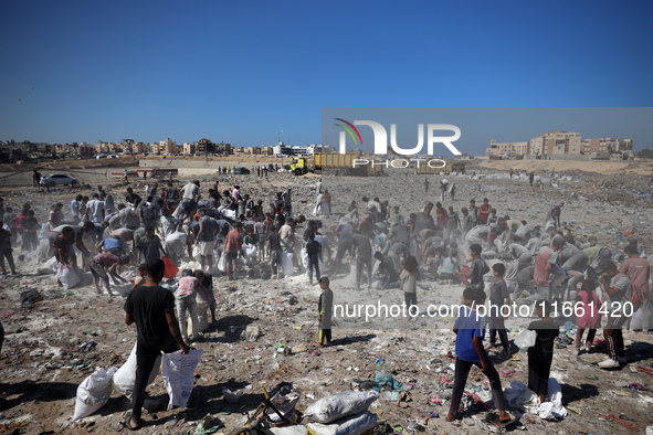 A photo shows Palestinian youths collecting remains of spoiled flour discarded in a makeshift landfill near the tents of displaced people in...