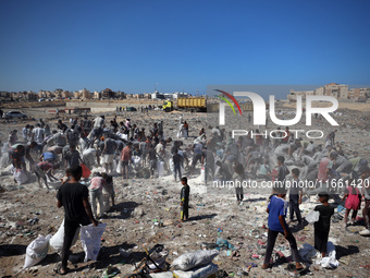 A photo shows Palestinian youths collecting remains of spoiled flour discarded in a makeshift landfill near the tents of displaced people in...