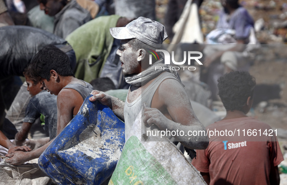 A photo shows Palestinian youths collecting remains of spoiled flour discarded in a makeshift landfill near the tents of displaced people in...