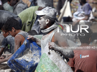 A photo shows Palestinian youths collecting remains of spoiled flour discarded in a makeshift landfill near the tents of displaced people in...