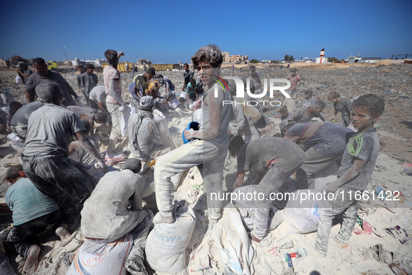 A photo shows Palestinian youths collecting remains of spoiled flour discarded in a makeshift landfill near the tents of displaced people in...