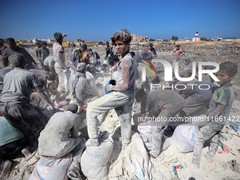 A photo shows Palestinian youths collecting remains of spoiled flour discarded in a makeshift landfill near the tents of displaced people in...