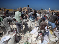 A photo shows Palestinian youths collecting remains of spoiled flour discarded in a makeshift landfill near the tents of displaced people in...