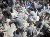 A photo shows Palestinian youths collecting remains of spoiled flour discarded in a makeshift landfill near the tents of displaced people in...