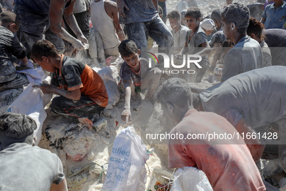 A photo shows Palestinian youths collecting remains of spoiled flour discarded in a makeshift landfill near the tents of displaced people in...