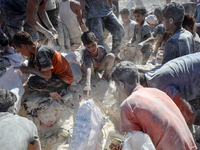 A photo shows Palestinian youths collecting remains of spoiled flour discarded in a makeshift landfill near the tents of displaced people in...