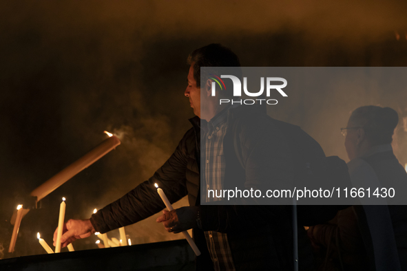 Pilgrims hold candles and pray during the candle procession at the Sanctuary of Fatima, in Fatima, Portugal, on October 12, 2024, on the ann...