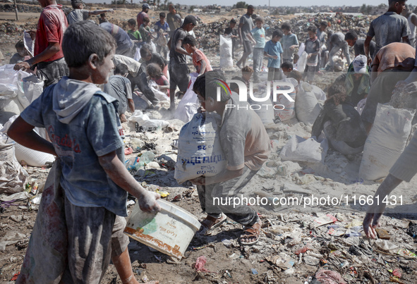 A photo shows Palestinian youths collecting remains of spoiled flour discarded in a makeshift landfill near the tents of displaced people in...