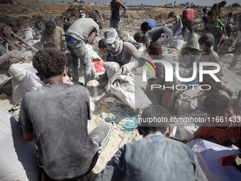 A photo shows Palestinian youths collecting remains of spoiled flour discarded in a makeshift landfill near the tents of displaced people in...