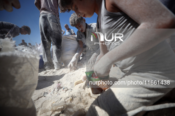 A photo shows Palestinian youths collecting remains of spoiled flour discarded in a makeshift landfill near the tents of displaced people in...