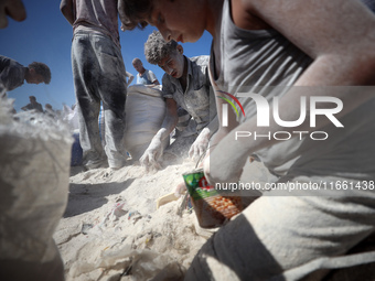 A photo shows Palestinian youths collecting remains of spoiled flour discarded in a makeshift landfill near the tents of displaced people in...