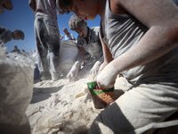 A photo shows Palestinian youths collecting remains of spoiled flour discarded in a makeshift landfill near the tents of displaced people in...