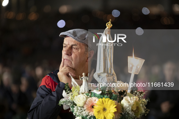 Pilgrims hold candles and pray during the candle procession at the Sanctuary of Fatima, in Fatima, Portugal, on October 12, 2024, on the ann...