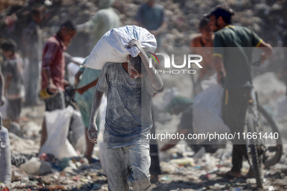 A photo shows Palestinian youths collecting remains of spoiled flour discarded in a makeshift landfill near the tents of displaced people in...