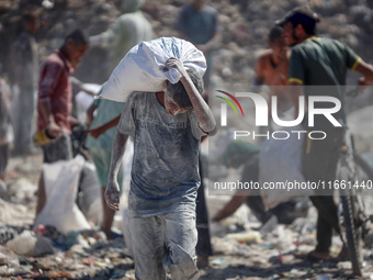 A photo shows Palestinian youths collecting remains of spoiled flour discarded in a makeshift landfill near the tents of displaced people in...