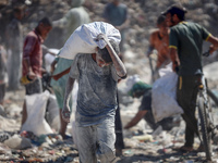 A photo shows Palestinian youths collecting remains of spoiled flour discarded in a makeshift landfill near the tents of displaced people in...