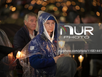 Pilgrims hold candles and pray during the candle procession at the Sanctuary of Fatima, in Fatima, Portugal, on October 12, 2024, on the ann...