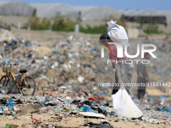 A photo shows Palestinian youths collecting remains of spoiled flour discarded in a makeshift landfill near the tents of displaced people in...