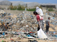 A photo shows Palestinian youths collecting remains of spoiled flour discarded in a makeshift landfill near the tents of displaced people in...