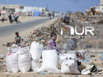 A photo shows Palestinian youths collecting remains of spoiled flour discarded in a makeshift landfill near the tents of displaced people in...