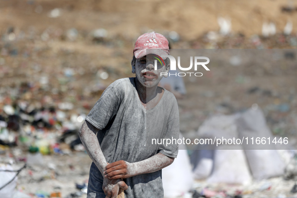 A photo shows Palestinian youths collecting remains of spoiled flour discarded in a makeshift landfill near the tents of displaced people in...